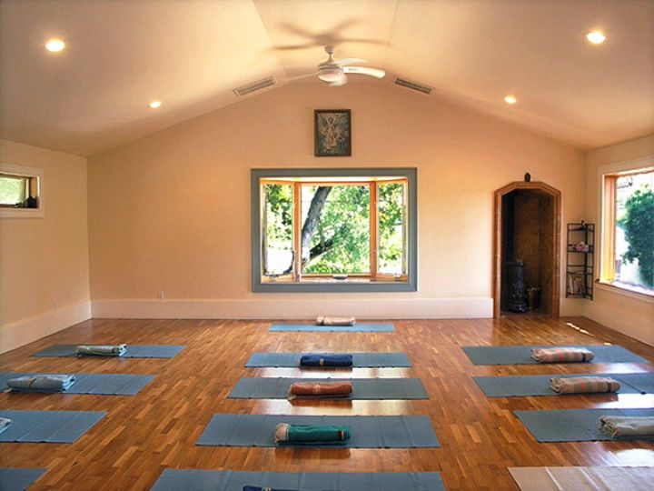 Photo of empty studio with yoga mats and blankets placed throughout.