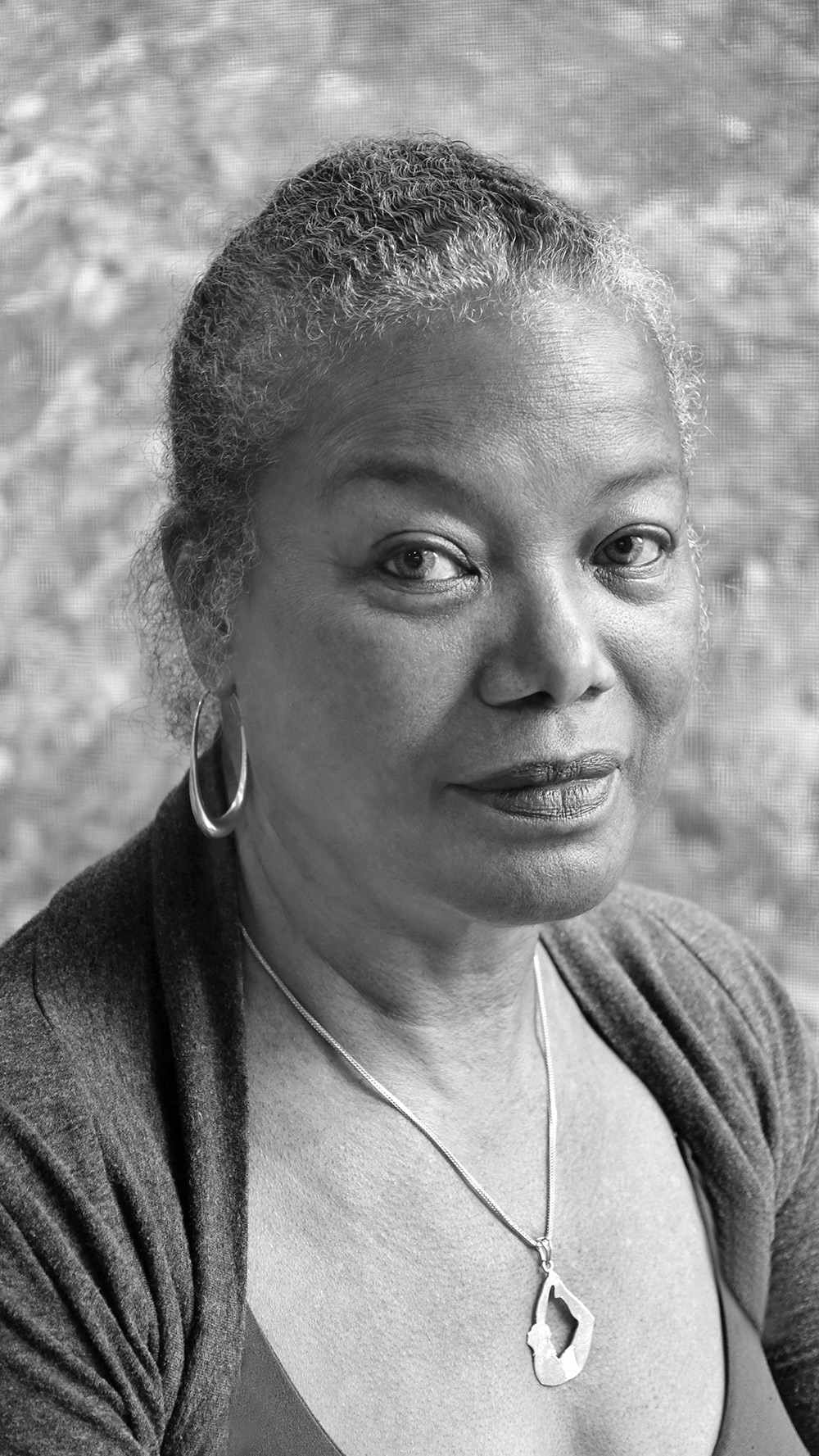 Photo of Jaki Nett, smiling, head titled in grayscale